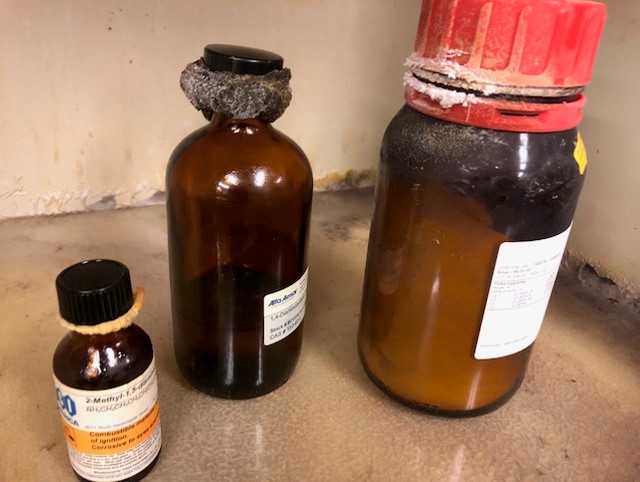 3 chemical bottles with extensive crystals near the caps