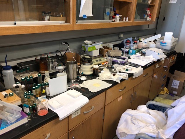 lab bench full of equipment and blocked cabinets