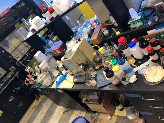 lab bench cluttered with chemicals and equipment