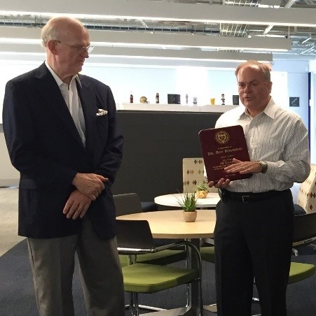 Dr. Steve Cross giving a plaque to Dr. Ron Rousseau