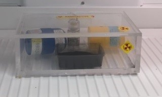 plexiglass box with radioactive source and tray of activated charcoal